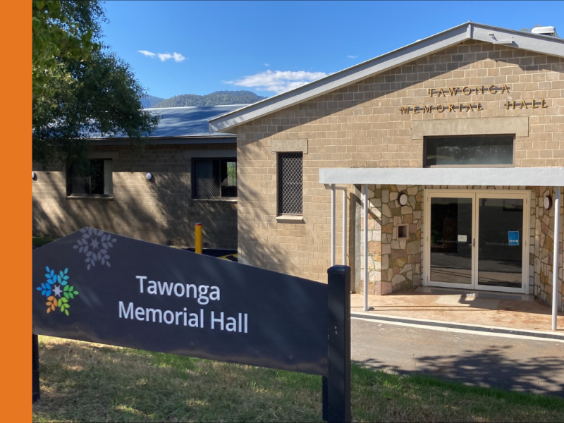 The exterior of Tawonga Memorial Hall, a blonde brick building with double entry doors.