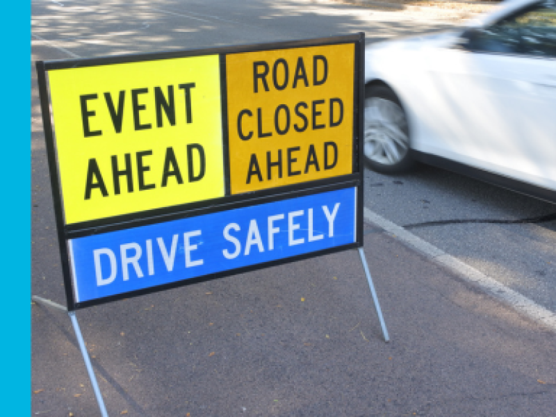 Event ahead, road closed ahead, drive safely sign