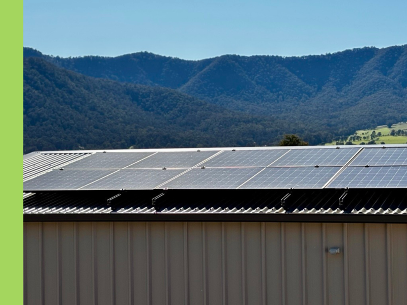 Solar panels on a shed roof with mountains in the background