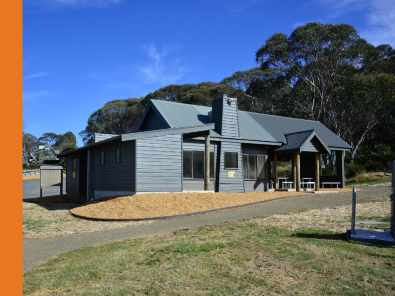A building with grey walls sitting in front of gum trees.