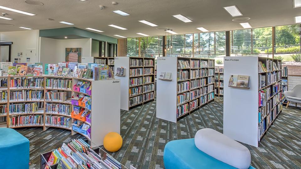 Interior of Myrtleford Library with a curved bookshelf to the left and rectangular bookshelves to the right.